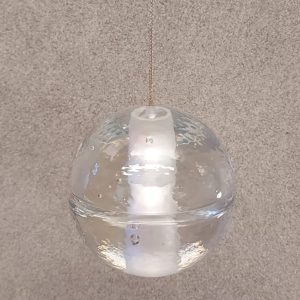 Pendente Bocci 14.1 . Cada pingente individual é uma esfera articulada de vidro fundido com um cilíndro fosco que abriga uma lâmpada LED.